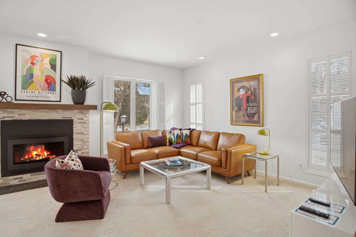 Enjoy the crackling fireplace in this stylish living room with plush leather seating and curated artwork.