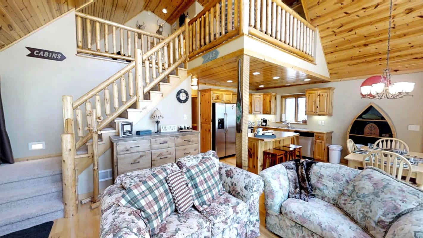 Relax in your cozy cabin retreat with vaulted ceilings, rustic charm, and an open layout connecting kitchen to living space.