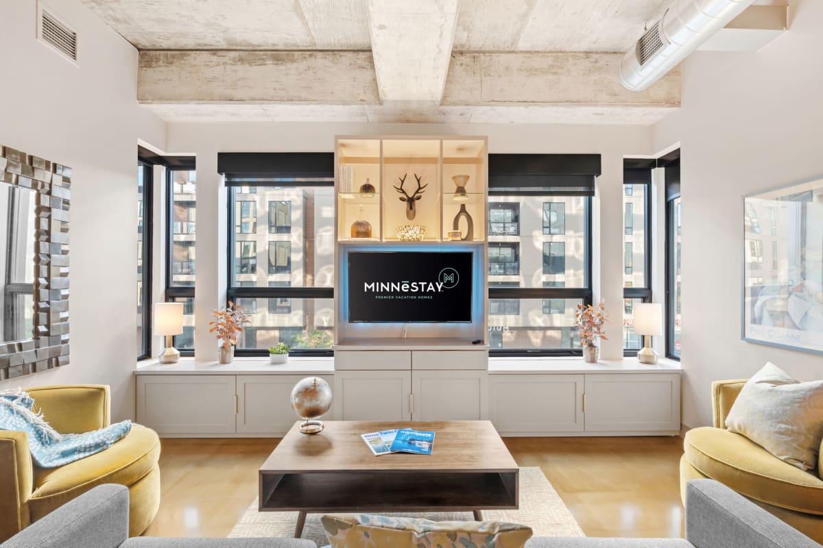 Unwind in your stylish living space with exposed beams, city views, and cozy seating perfect for relaxing evenings.