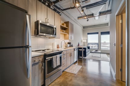 Contemporary apartment kitchen with stainless steel appliances and sleek design.