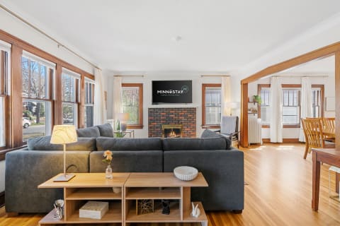 Cozy living room with a gray sectional couch and a brick fireplace.