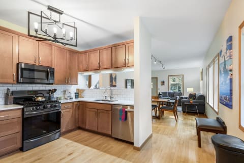 Interior view of a kitchen and dining area with wooden cabinets and modern appliances.
