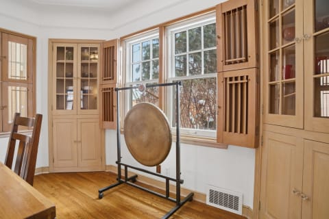 A serene room featuring built-in wood cabinetry and a traditional gong for meditation.