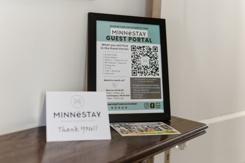 A display with a MINNESTAY information sheet and a thank you card on a wooden surface.