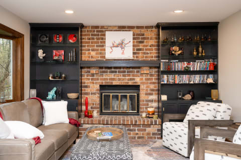 Cozy living room featuring a brick fireplace and modern furniture.