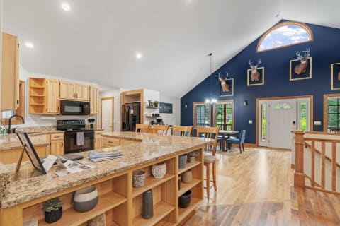 Spacious kitchen with wooden cabinetry and a dining area featuring a blue accent wall.