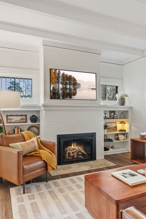 Cozy living room with a fireplace, leather armchair, and modern decor.