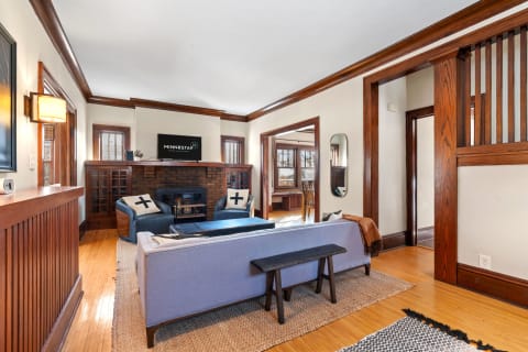 Living room with wooden accents, gray sofa, and cozy armchairs.