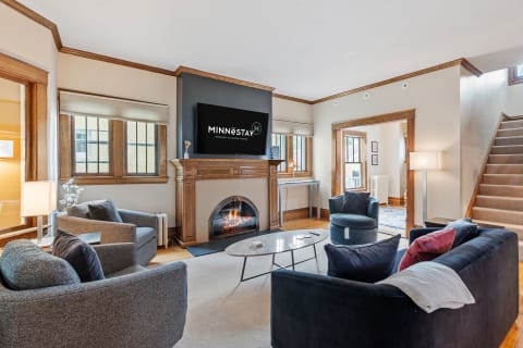 Inviting living room with a fireplace, flat-screen TV, and modern furniture.