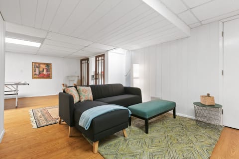 Cozy living space featuring a gray sectional sofa, colorful pillows, and a modern decor style.