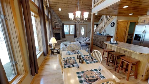 Interior view of a cozy cabin with a dining table and a living area.