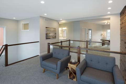 A stylish gray seating area with wooden accents and a decorative table, illuminated with soft lighting.