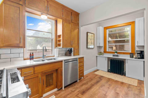 A cozy kitchen featuring wooden cabinets, white countertops, and a window view.