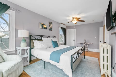 Cozy bedroom with a metal bed frame, plush bedding, and modern furnishings.