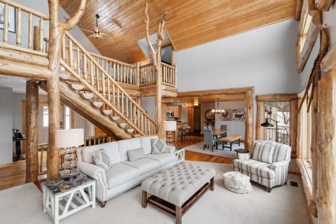 Spacious lodge interior featuring wooden staircase and cozy living area.