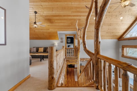 Interior view of a loft featuring wooden ceilings and rustic furniture.