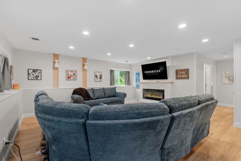 Cozy basement living room showcasing a sectional sofa, fireplace, and playful wall art.