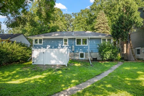 Residential house with a blue exterior and green lawn.