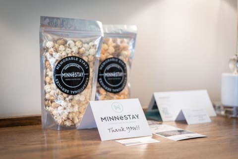 Thank you card and popcorn bags from MINNĒSTAY on a wooden countertop.