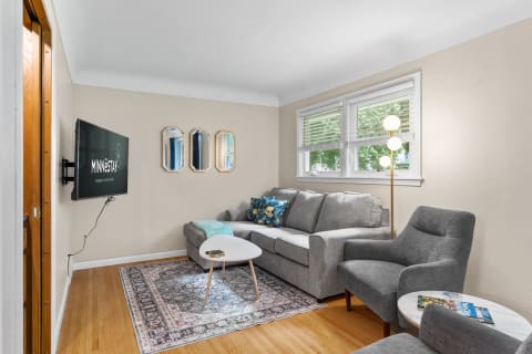 Cozy living room with gray sofa, TV, and decorative mirrors.