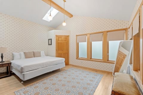 A cozy bedroom featuring a bed, wooden accents, and frosted windows.