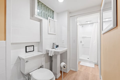 An elegantly designed bathroom with a toilet, sink, and shower space.