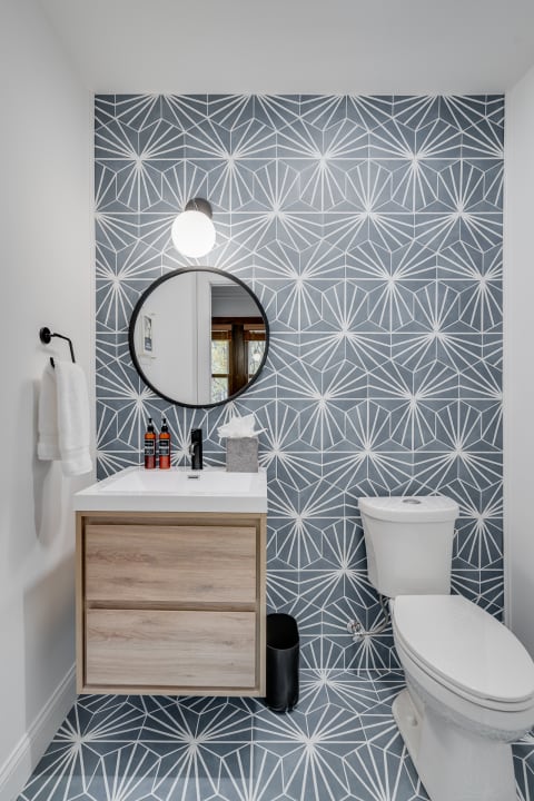 Contemporary bathroom with geometric patterned wall and sleek fixtures.