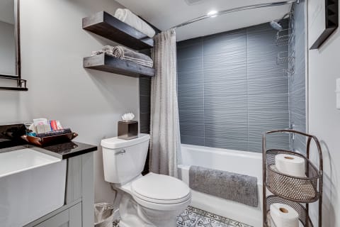 Modern bathroom with gray decor, sleek fixtures, and patterned floor tiles.