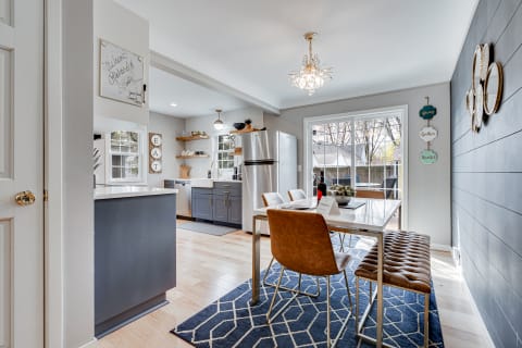 Modern kitchen and dining area featuring an island, dining table, and elegant chandelier.