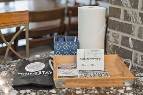 An arrangement of vacation essentials including brochures, a thank you note, a pen, and paper towels on a marble surface.