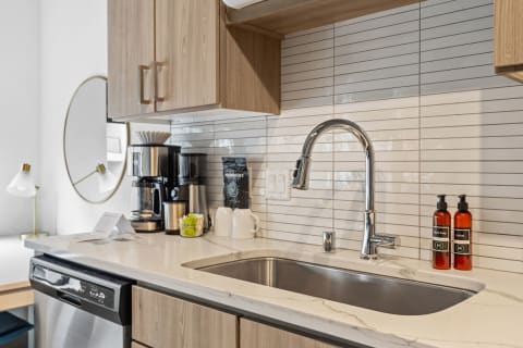Modern kitchen appliances and décor including a sink, coffee maker, and stylish cabinetry.