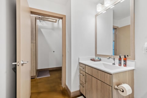 Contemporary bathroom interior with white sink and large mirror.