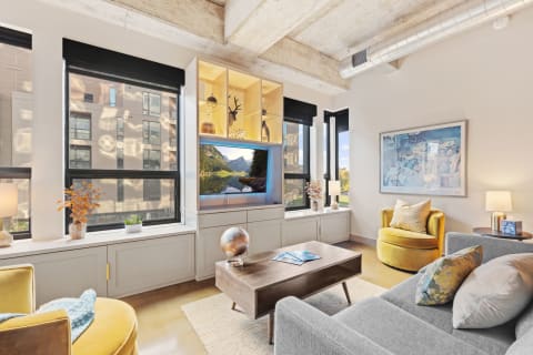 Stylish modern living room with a large TV, decorative shelves, and comfortable seating.