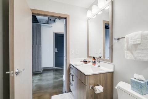 Contemporary bathroom with a white vanity and polished concrete floor.