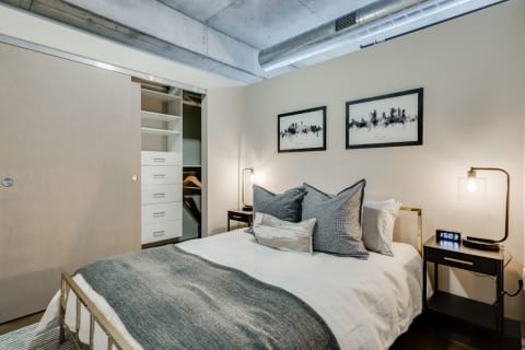 Modern bedroom featuring a neatly made bed, contemporary decor, and a sliding closet door.