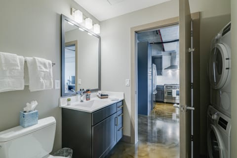 Interior view of a modern bathroom transitioning into a contemporary kitchen.