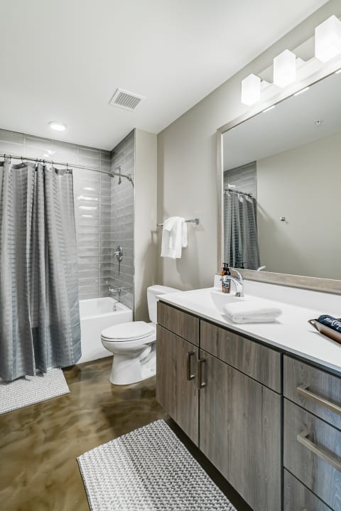 A modern bathroom featuring a shower, bathtub, vanity, and neutral color scheme.