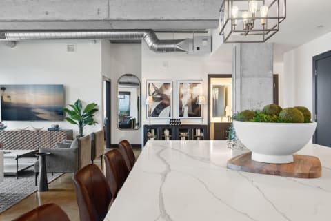 Stylish modern apartment featuring a marble countertop, leather barstools, and contemporary decor.