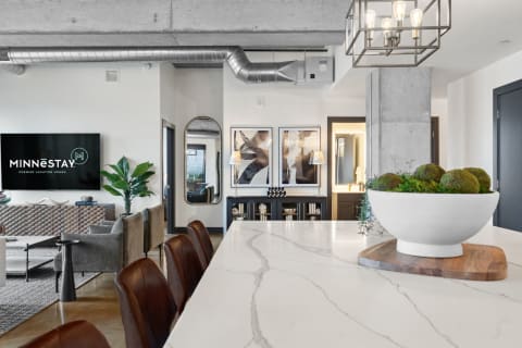 Contemporary kitchen and living area featuring marble countertops and decorative elements.