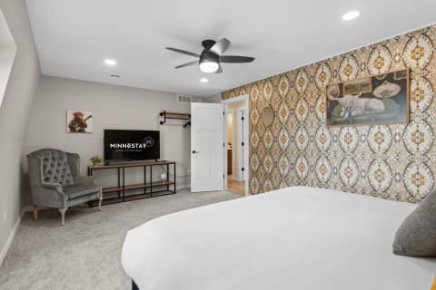 Stylish bedroom with intricate wallpaper, a large bed, and modern decor.