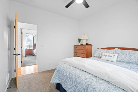 Cozy bedroom featuring a blue paisley quilt and an adjoining room view.