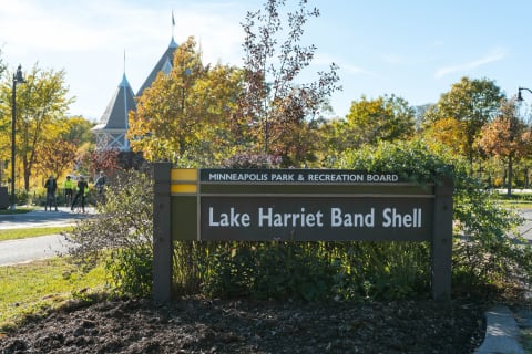 View of the Lake Harriet Band Shell sign surrounded by colorful autumn foliage.