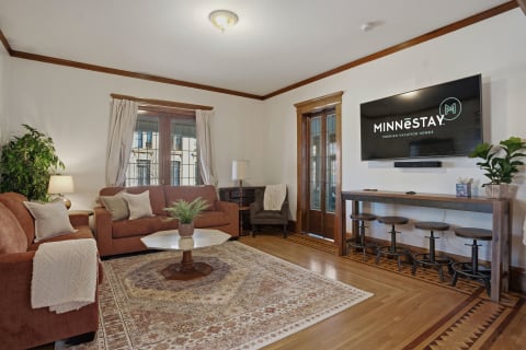 Cozy living room featuring rust-colored sofas, a marble coffee table, and modern amenities.