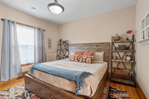 Interior view of a warm and inviting bedroom with a wooden bed and decorative shelves.