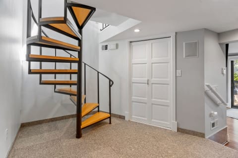 Interior view featuring a modern spiral staircase and double doors.