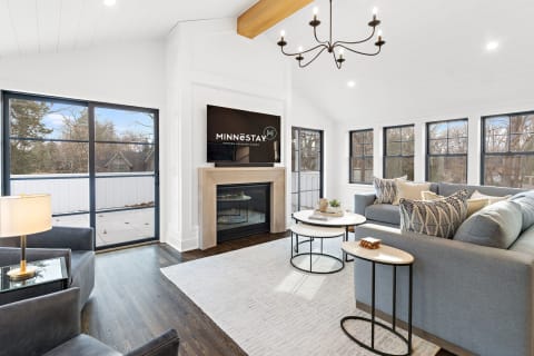 Interior view of a modern living room with a sofa, fireplace, and large windows.