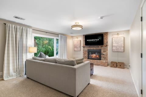 Inviting living room with a sectional sofa, brick fireplace, and modern decor.