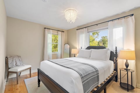 Cozy bedroom featuring a queen-size bed, natural light, and elegant decor.