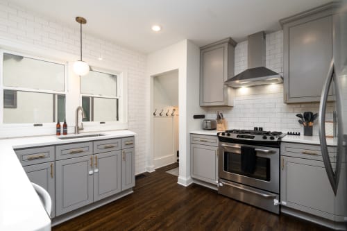 Cook your favorite meals in this stylish kitchen with modern gray cabinets, stainless steel appliances, and bright subway tile backsplash.