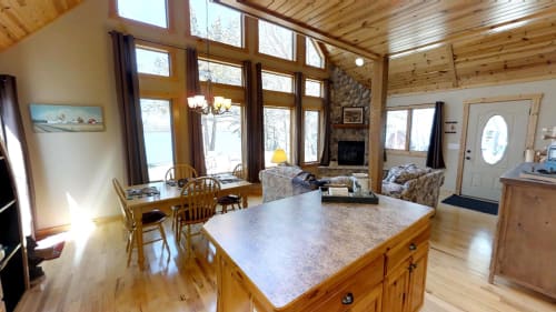 Your cozy mountain retreat features an open-concept living space where you'll enjoy lakefront views while cooking, dining, and relaxing by the stone fireplace.